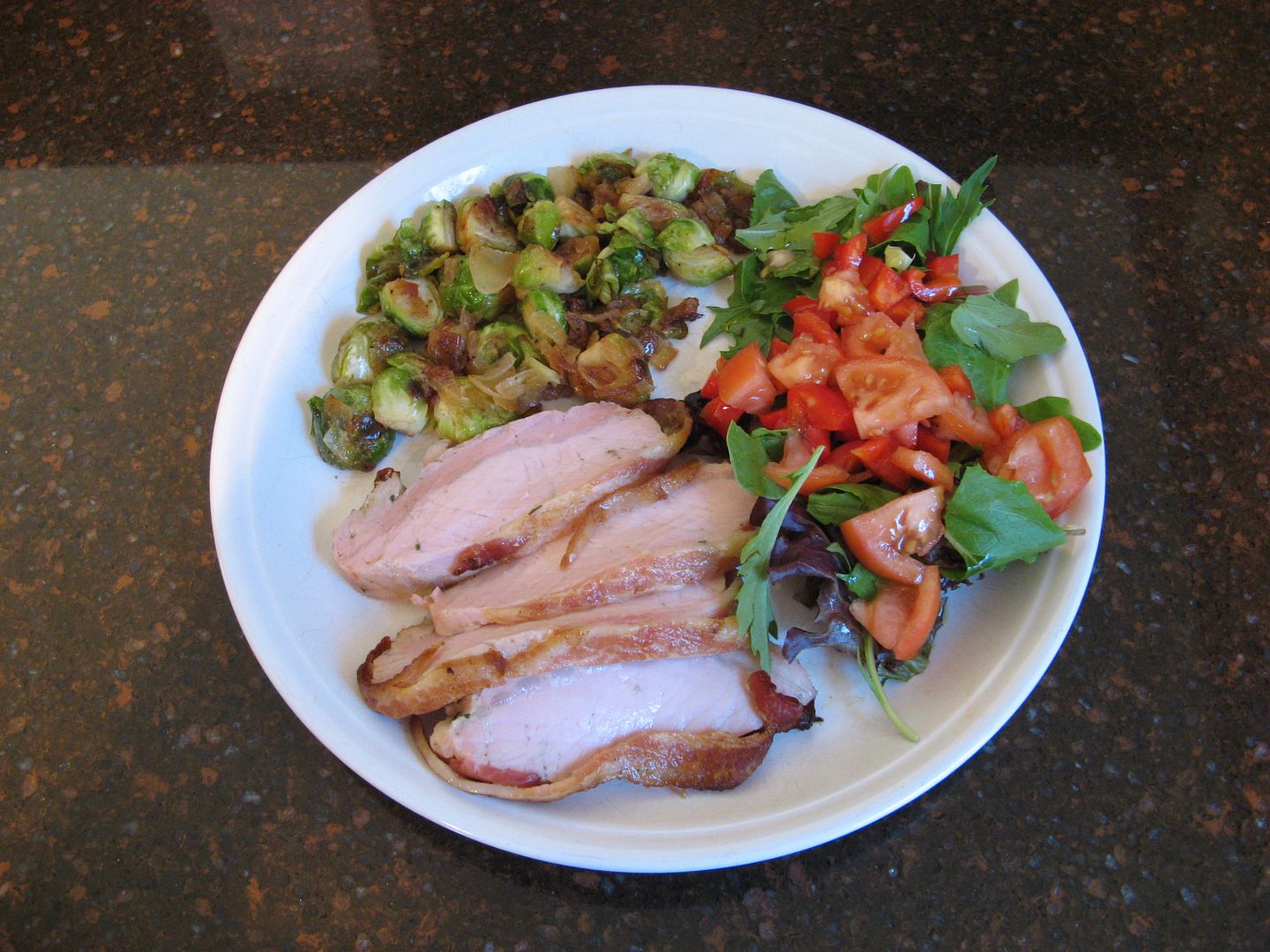 Pork tenderloin wrapped in bacon, Brussels sprouts and onions sauteed in bacon fat and a Mixed greens salad dressed with olive oil and balsamic vinegar