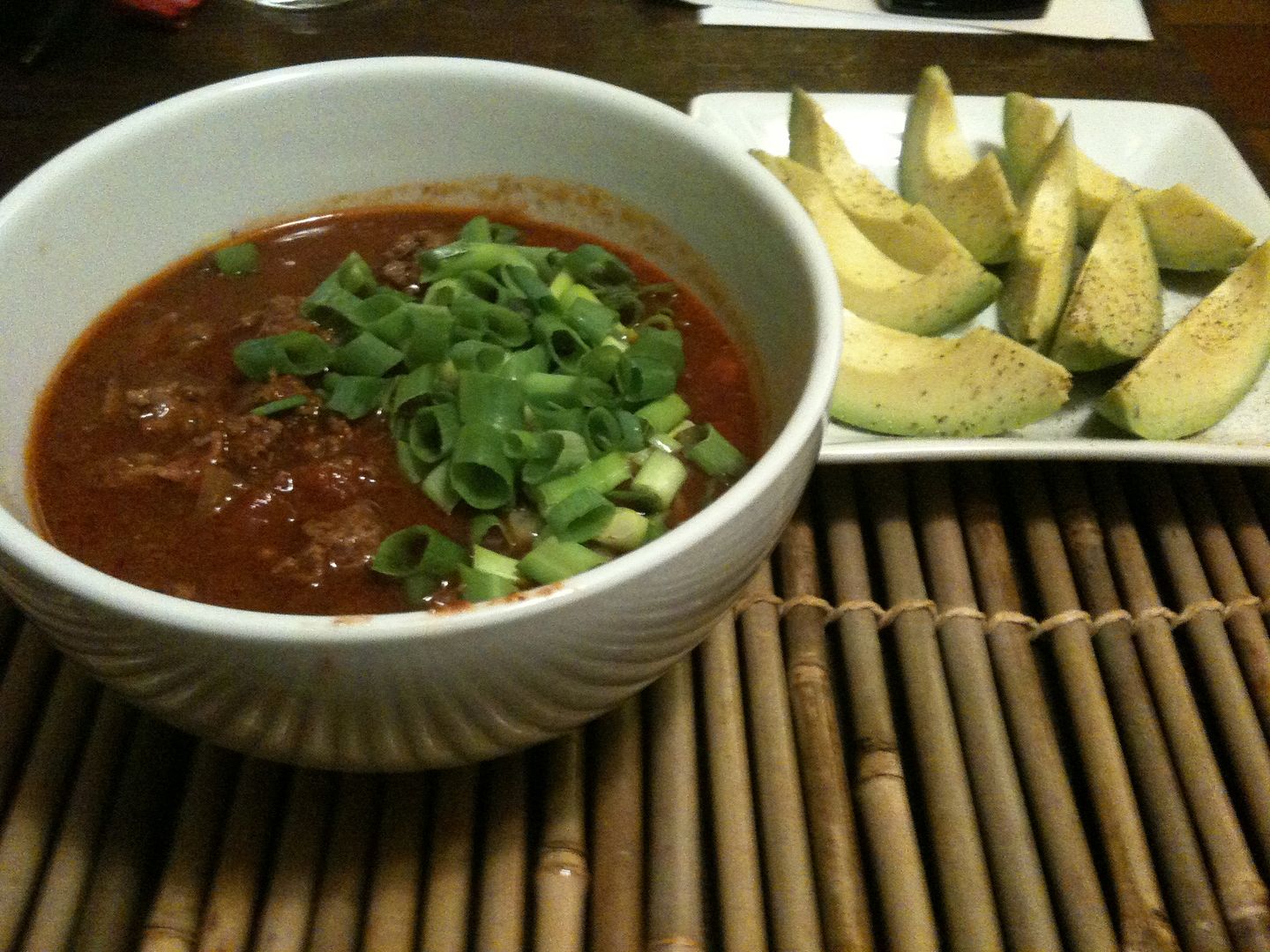 Primal chili with sliced avocados